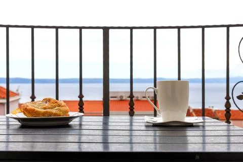 Side view of a white cup of tea and  plate with burek pastry on a balcony t.. Stock Photos