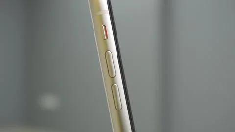 Side view of white phone close up view. Hand toggle mute button to switch on Video stock 250516311