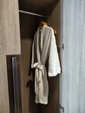 Side View of White Spa Bathrobe Inside Wooden Wardrobe 스톡 사진