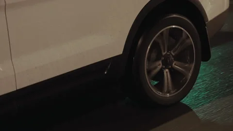 Side view of white SUV car rear wheel spinning and riding on wet asphalt road Stock Footage 196290315