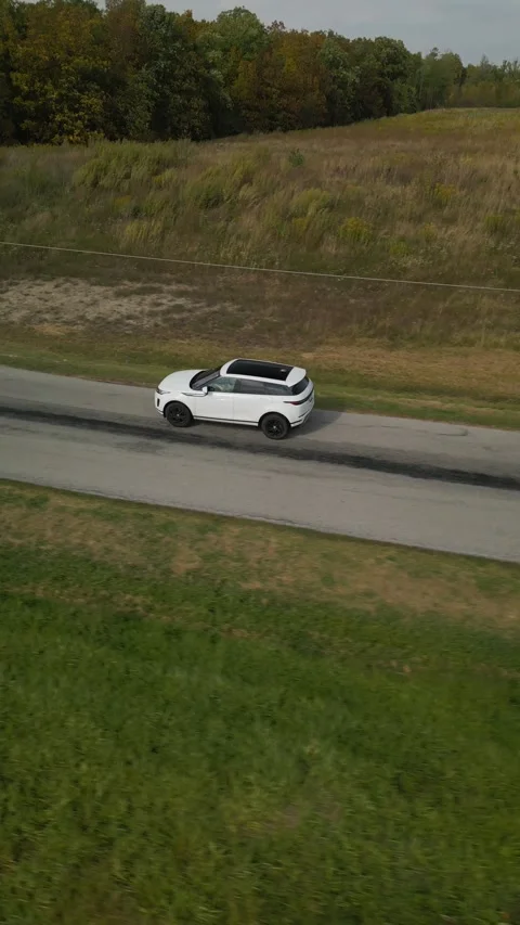 Side view of a white SUV driving on a rural road in Ontario, Canada Video stock 317592477