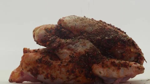 Side View Of A Whole Chicken Having Herbs Poured On It, On A White Background Stock Footage 143092777