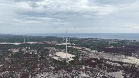 Side view of wind turbine towering over coastal landscape 4K Stock Footage 339862766