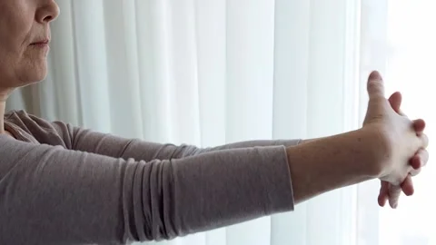 Side view of a woman doing an exercise for hands and fingers relieves tension, f Stock Footage 171107638