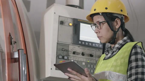 Side view of woman engineer working on machine and check with tablet digital Stock Footage 137140488