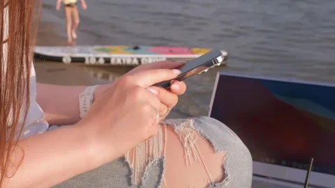 Side view woman in hat at beach with laptop, using smartphone, online chatting Stock Footage 244485585