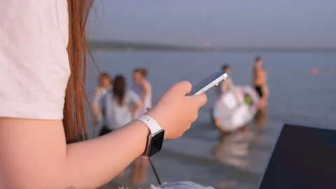 Side view woman in hat at beach with laptop, using smartphone, online chatting Stock-Footage 244803424