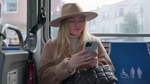 Side view of a woman in a hat observing city views, while sitting in a streetcar Stock Footage 223238372