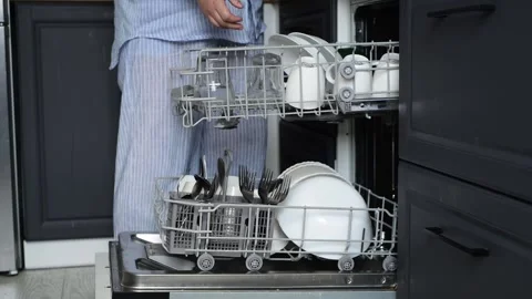 Side view of woman loading dishwasher with dirty plates, bowls, cutlery Vídeo Stock 328996164
