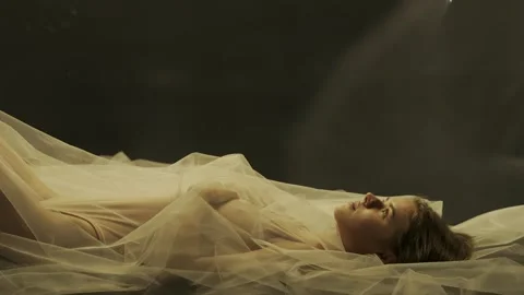 Side view of a woman lying with her arms folded across her chest. The woman is Stock Footage 263044007