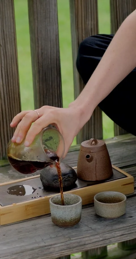 Side view of a woman pouring fermented Chinese Pu-erh... Stock Footage 344454847