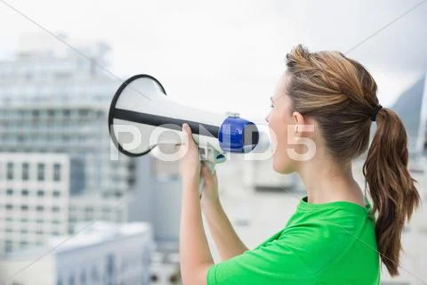 Side view of woman using megaphone Stock Photos