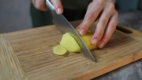 A side view of a womans hands chopping potatoes on a cutting board. Preparing Video stock 313293504