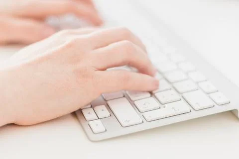 Side view of woman's hands typing on a keyboard Photos