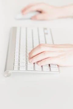 Side view of woman's hands using a keyboard and a computer mouse Foto stock