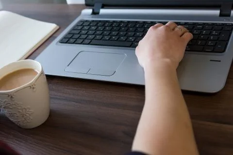 Side view of woman's hands writing on laptop. Stock Photos