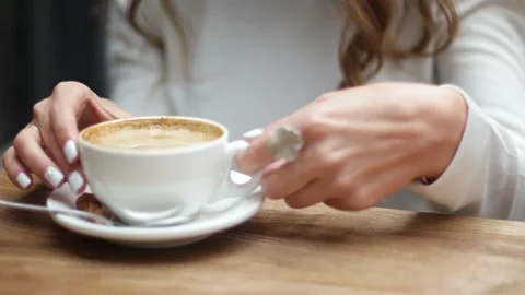 Side view of women hands with white cup of black coffe on light wooden table Stockbeeldmateriaal 146472017