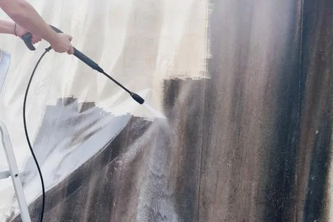 Side view of worker hand holding high pressure washer lance to clean dirty .. 写真素材
