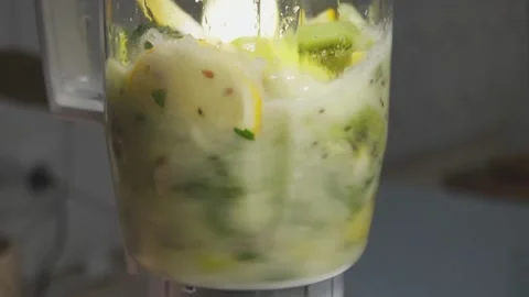 Side view of working electric blender preparing green smoothie, blending kiwi Stock Footage 238810966