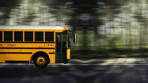 Side view of a Yellow Bus driving on highway at high speed, forest background. Video stock 332430160