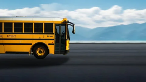 Side view of a Yellow Bus driving on highway at high speed, sky and mountains. 스톡 동영상 332430254