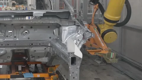 Side view of a yellow robotic arm performing a precision task on the front Stock Footage 332975799