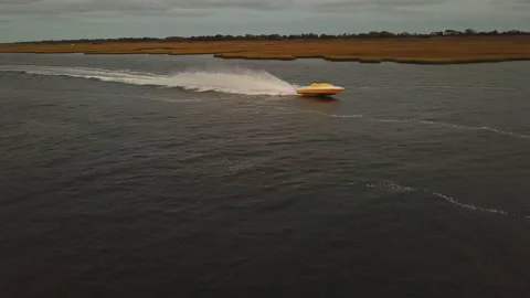 Side view of yellow speed boat rooster tail drone view Stock Footage 148510703