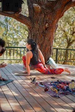 Side View of Yoga Instructor Performing Crescent Lunge Pose on Forest Terrace. Stock Photos