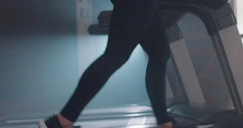 Side view of young attractive pretty woman in sportswear running on treadmill at Stock Footage 149484191