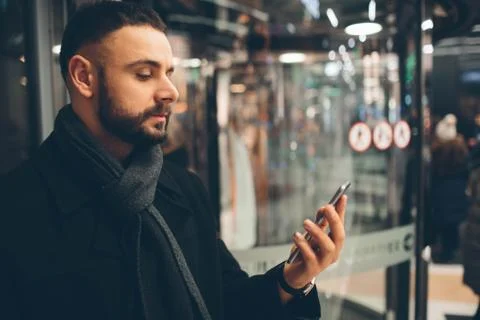 Side view of young bearded man,dressed incasual wear, he is standing on the Stock Photos