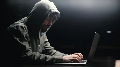 Side view of young bearded programmer hacking online site or password at desk in Video stock 145121566