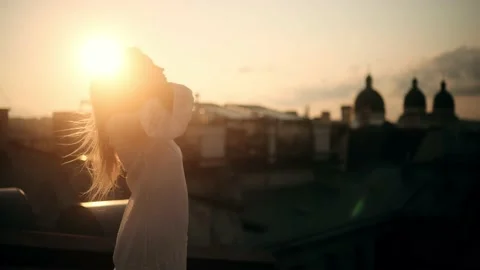 Side View of Young Beautiful Blonde Woman in a white Dress fix her hair on a Stock Footage 160199110