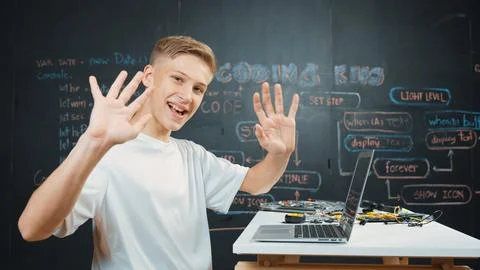 Side view of young boy programing code while looking at camera. Edification. Stock Photos