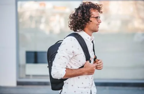 Side view of young buasinessman with backpack on the city street. Caucasian m Stock Photos