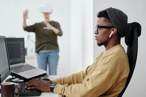 Side view of young businessman decoding data while looking at computer screen Stock Photos
