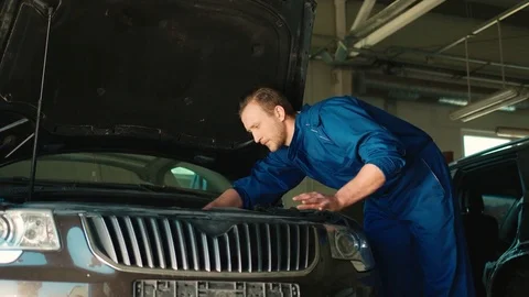 Side view of young caucasian auto mechanic man nuting of the screwed using nut Stock Footage 76247324