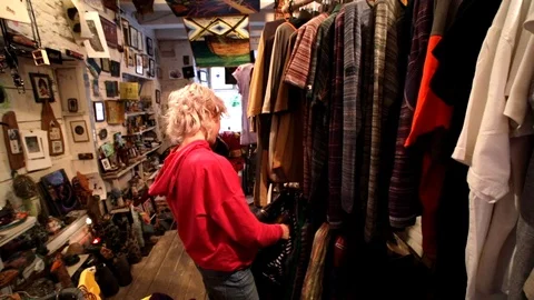 Side view of young caucasian blonde woman looking for some original clothes Vídeos de archivo 116529938