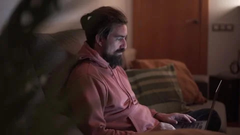 Side view of young Caucasian handsome man concentrating on laptop sitting on Stock Footage 255669172