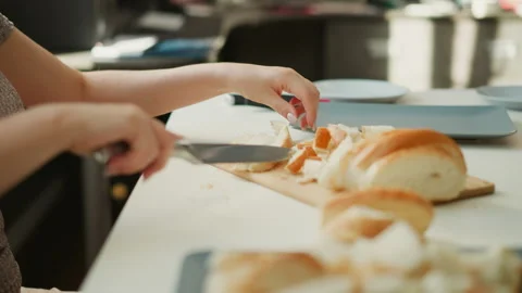 Side View Of Young Chef Cutting Bread Loaf Into Small Pieces Stock Footage 307978413
