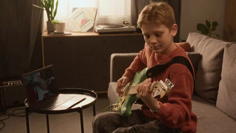 Side View of Young Child Prodigy Playing Electric Guitar at Home Stock Footage 333426805