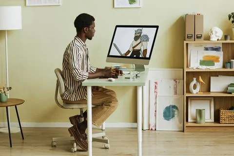 Side view of young creative digital artist sitting in front of computer monitor Foto stock