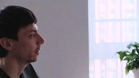 Side view of a young dark-haired talking man. He looks in front of him Vídeo Stock 136888989