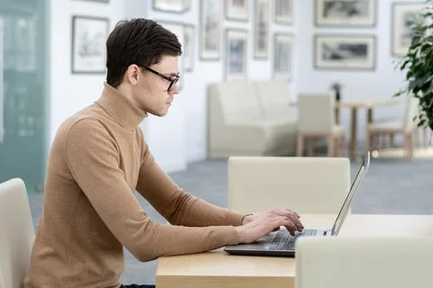 Side view of young developer of technology company typing on laptop keyboard Stock Photos