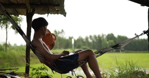 Side view of Young farmer man without shirt sit on the hammock and look out  Stock Footage 202054704