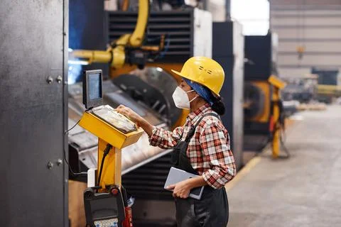 Side view of young female engineer looking through information by screen Stock Photos