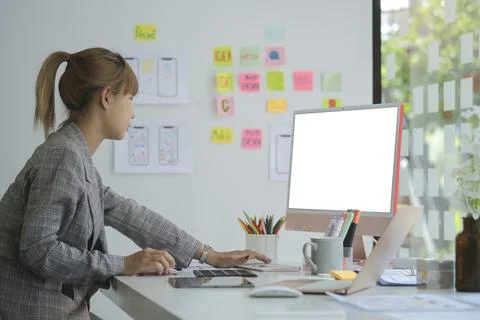 Side view of young female web developer working on mobile application softwar Stock Photos