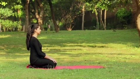 Side view of a young girl practicing shashankasana / the hare pose yoga Stock Footage 116087448
