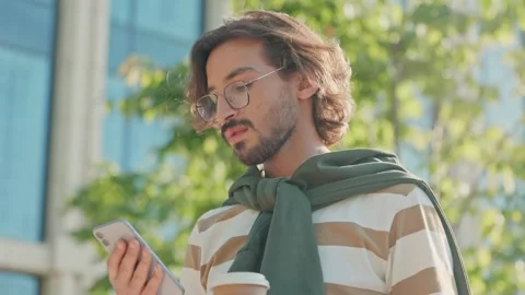 Side view of young guy holding coffee cup and phone. Caucasian man drinking Video stock 278910901