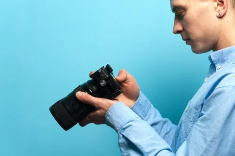 Side view of a young guy photographer Stock Photos