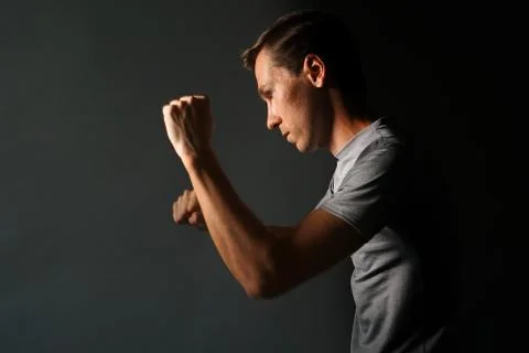 Side view of young handsome man making punches. Low key photography Stock Photos